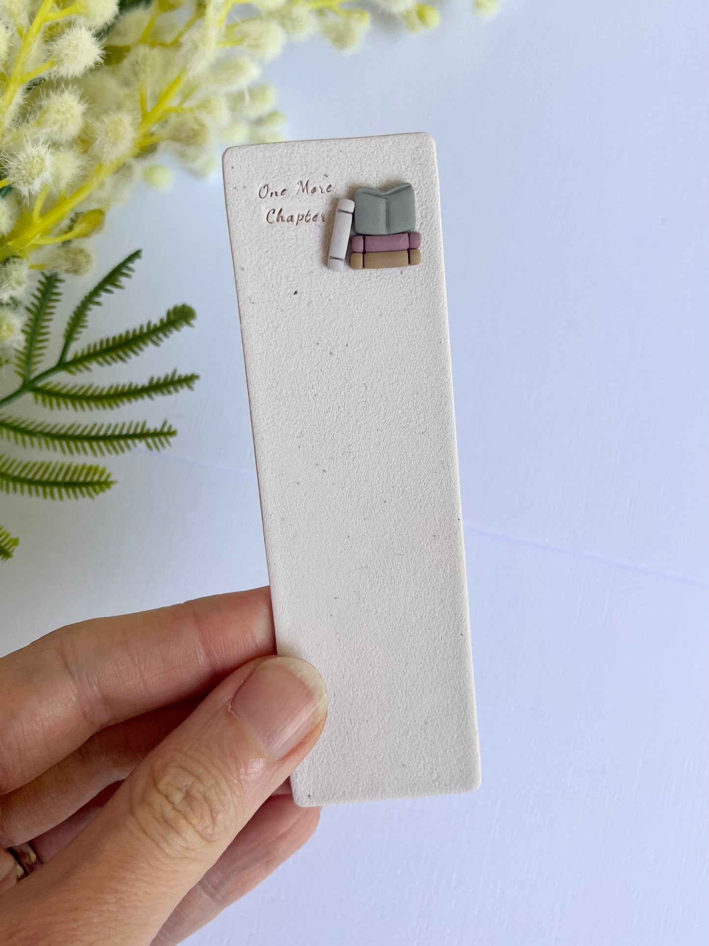 Earring on a display card held by a hand with a light background